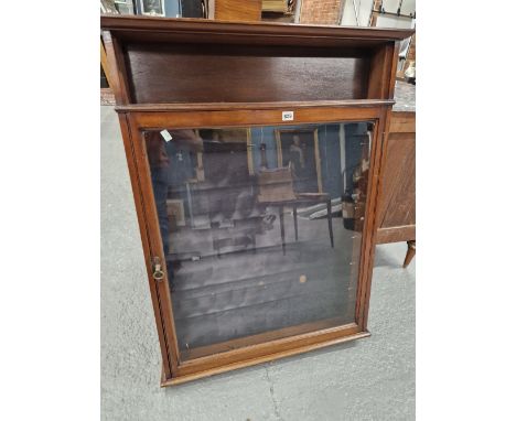 A MAHOGANY WALL MOUNTING DISPLAY CABINET WITH A GLAZED DOOR UNDER AN OPEN SHELF AND ENCLOSING SHELVES BACKED BY DEEP BLUE VEL