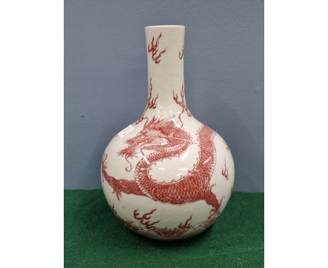 A CHINESE UNDERGLAZE RED BOTTLE VASE DECORATED WITH A DRAGON CHASING A FLAMING PEARL, SEAL MARK IN BLUE. H 27cms.*********IF 