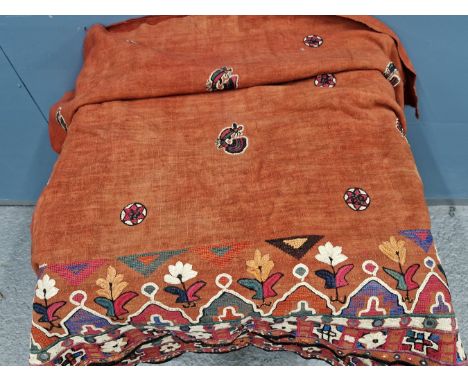A RUST RED SUSANI PANEL, THE FIELD EMBROIDERED WITH ROUNDELS AND COCKERELS, THE BORDER WITH LAPPETS, FLOWER STEMS AND MIRRORE