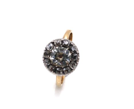 AN ANTIQUE DIAMOND RING WITH CENTRAL CUSHION OLD CUT DIAMOND WITHIN AN ELEVEN STONE HALO SURROUND, THE CENTRAL STONE MEASURIN