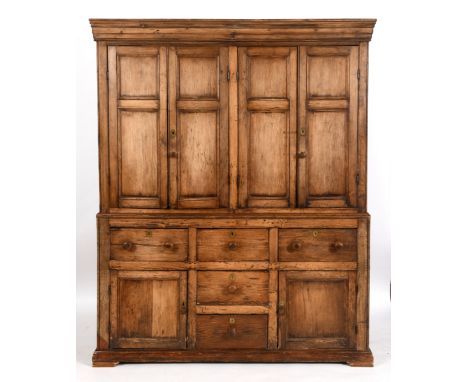 A stripped pine housekeeper's style cupboard, having two pairs of panel doors above a base with five drawers and a further pa