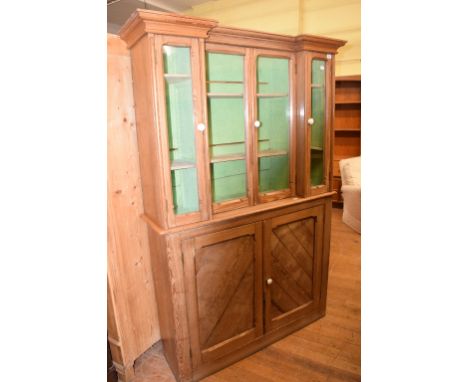 A Victorian pitch pine cabinet on cupboard, having two pairs of glazed doors above a pair of panel doors, 123 cm wide 