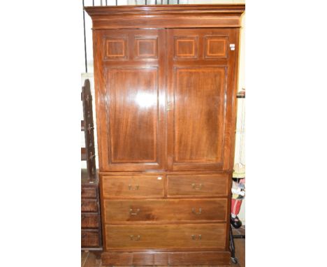 An Edwardian inlaid mahogany linen press, having a pair of panel doors above two short and two long drawers, on a plinth base