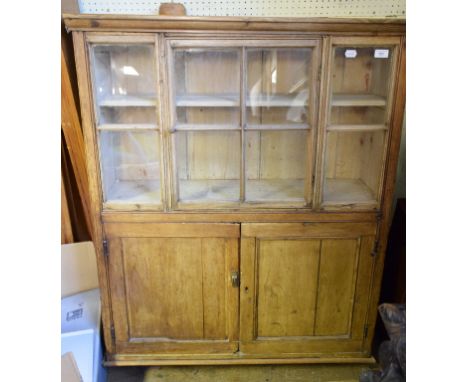 A small pine cupboard, having a glazed section above a pair of panel doors, 98 cm wide 
