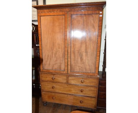 A Victorian mahogany linen press, having a pair of panel doors above two short and two long drawers, on turned feet, 132 cm w