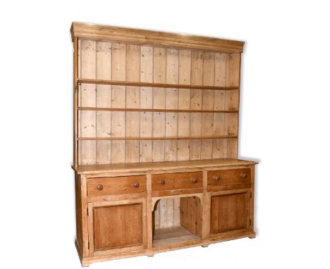 A stripped pine kitchen dresser, the three tier plate rack above a base with three frieze drawers, a central dog kennel and a