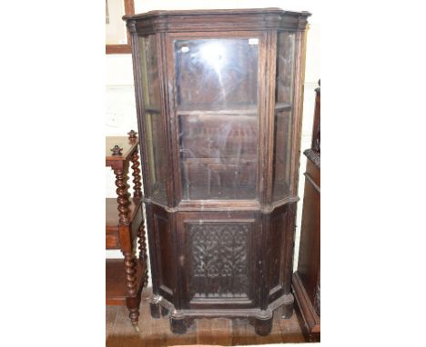 An oak display cabinet, having a glazed door above a panel door, incorporating 17th century carvings, 86 cm wide 