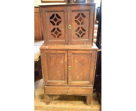 A mahogany cabinet, in two parts, having a pair of pierced panel doors above a pair of panel doors, with a drawer below, 66 c