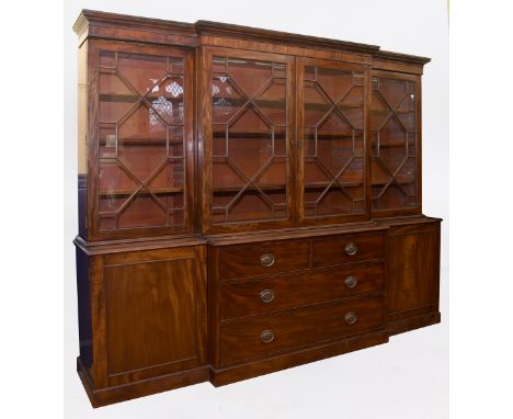 A breakfront mahogany library bookcase, having a pair of bar glazed doors flanked by two further bar glazed doors, above a ce