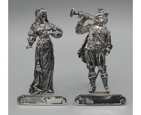 A pair of cast sterling silver menu card holders in the form of a Cavalier, with a bugle and his lady. With stands and clips 