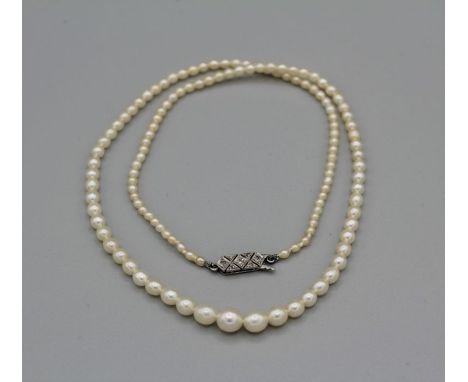 A single strand of graduated natural saltwater pearls with a diamond studded Art Deco clasp - with laboratory report. Cream c