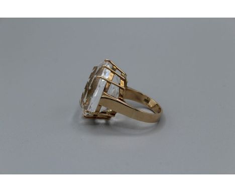 A large Oval mixed cut rock crystal cocktail ring in yellow metal setting. The stone measures approximately 26mm by 21.5mm by