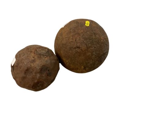 Large antique iron cannon ball, together with another smaller cannon ball, the largest approx. 20cm in height (2).