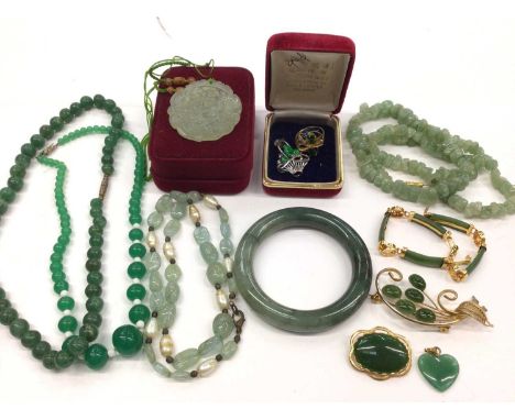Group of jade/ green hardstone jewellery including 14ct gold ring, white gold pendant in the form of a basket, polished bangl