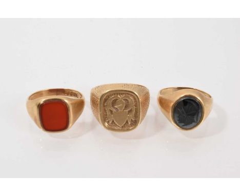 Three 9ct gold signet rings to include a polished carnelian panel, carved hematite intaglio depicting a Roman soldier's head 