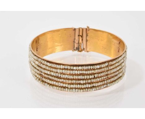 Eastern yellow metal bangle with six rows of strung seed pearls, 18cm inner circumferenceWeight 27.1 grams
