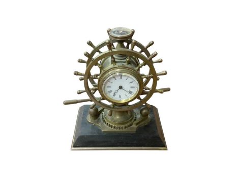 Antique novelty brass nautical combination clock, aneroid barometer and compass, in the form of a ship's wheel, on a black ma