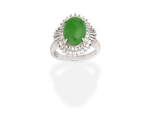 JADE AND DIAMOND RINGThe oval jadeite jade cabochon within a double brilliant-cut diamond surround, with tapered baguette cut