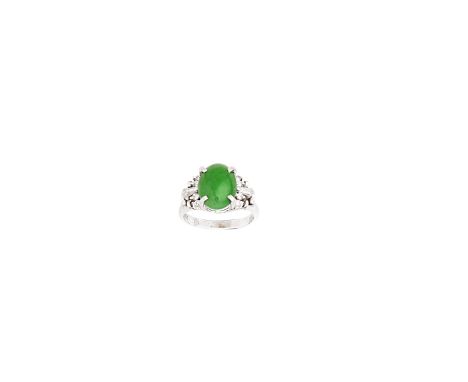 JADE AND DIAMOND RINGThe oval jadeite jade cabochon between quartets of brilliant-cut diamonds, with tapered baguette-cut dia