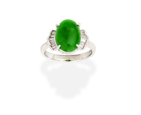 JADE AND DIAMOND RINGThe oval jadeite jade cabochon between scalloped shoulders, set with tapered baguette-cut diamonds, ring