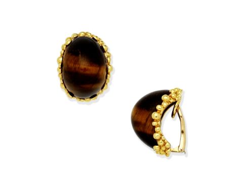 KUTCHINSKY: TIGER'S EYE EARCLIPS, CIRCA 1970Each of bombé design, the tiger's eye panel within beaded textured frames,  signe