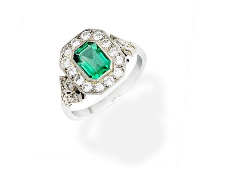 EMERALD AND DIAMOND RINGThe step-cut emerald within an old brilliant-cut diamond surround, the shoulders set with single-cut 