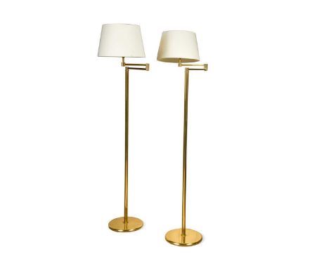 A pair of brass articulated reading lamps, each with an extendable hinged arm and weighted circular base125cm high to lamp ho