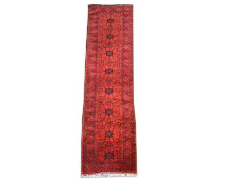 A finely-woven Ersari runner rug, with a row of eight medallions on a madder field and kelim ends390 x 97cmSuperb condition w