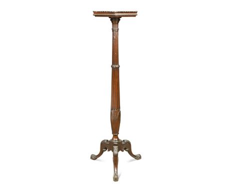 A George III style mahogany torchere, the hexagonal top with carved gilt wood edge on a reeded column support terminating on 