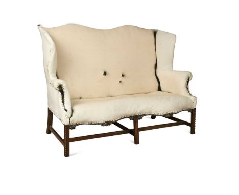 A George III style mahogany hump back sofa, 19th century, the shaped high back over a serpentine front raised on carved legs 