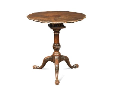 A George III mahogany tripod table with bird cage support, the scallop shaped tilt-top with carved edge decorated with flower
