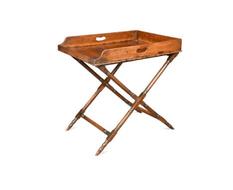 A large mahogany butler's tray on stand, early 19th century, the rectangular tray with pierced carrying handles and a ring tu