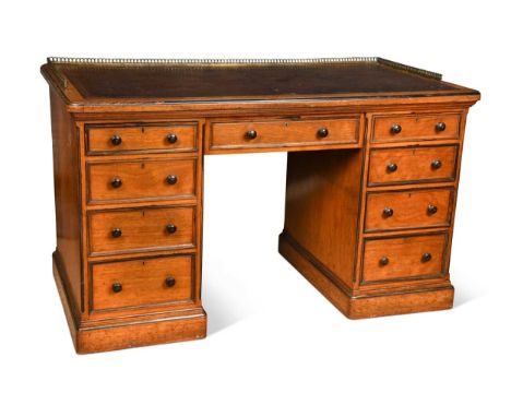 A late Victorian pollard oak kneehole desk, the pierced brass three-quarter gallery above a combination of nine drawers, top 