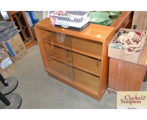 A light oak bookcase with glass sliding doors