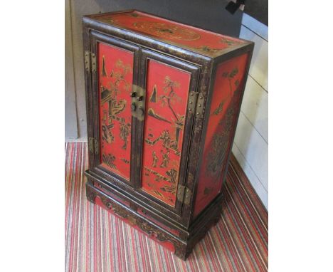 CHINESE CABINET, red and black lacquered decorated with bats, figures and bird and floral decoration having two panelled door