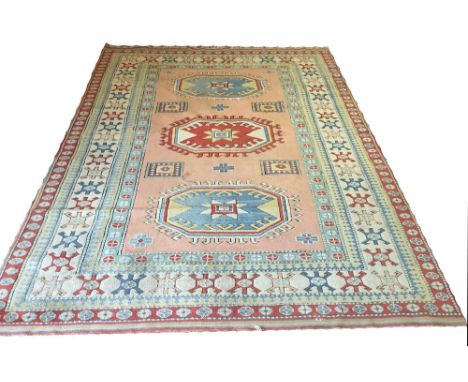 TURKISH MILAS CARPET, 290cm x 216cm, row of hooked medallions on a salmon field within multiple corresponding borders.