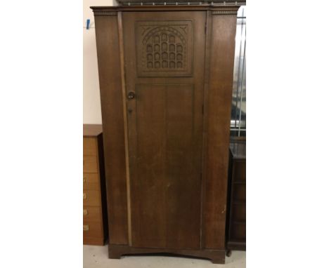 A vintage single wardrobe with portculis style decoration to door. Made by L. Marcus Ltd, London N1. 190cm tall x 94cm wide.