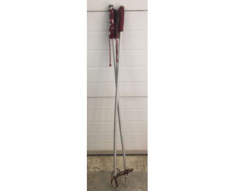 A pair of vintage ski poles with leather straps.