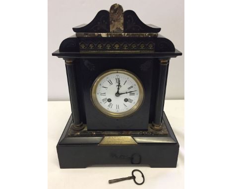 A Victorian French marble mantle clock. Movement marked AD Mougin. Black and brown marble with columns to front, enamel dial 