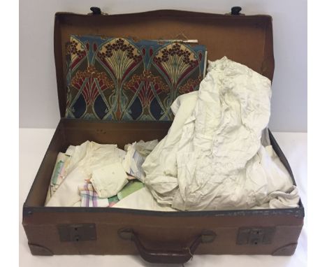 A vintage brown suitcase with contents to include material with Liberty 'Vat colours' pattern and vintage cotton nightdresses