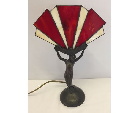 A metal based Art Deco style winged lady table lamp with red & cream leaded glass shade.