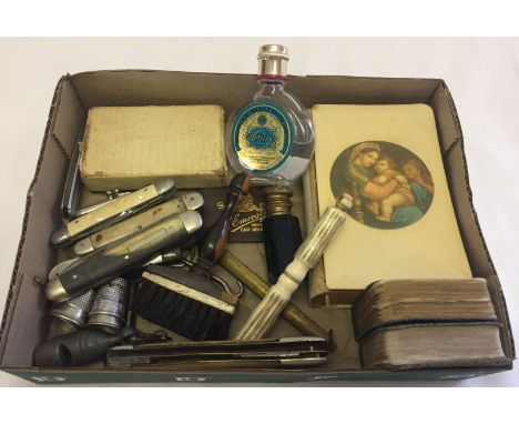 A small box of misc items to include penknives, a bottle of 4711 eau de cologne, advertising thimbles and a vintage needle ca