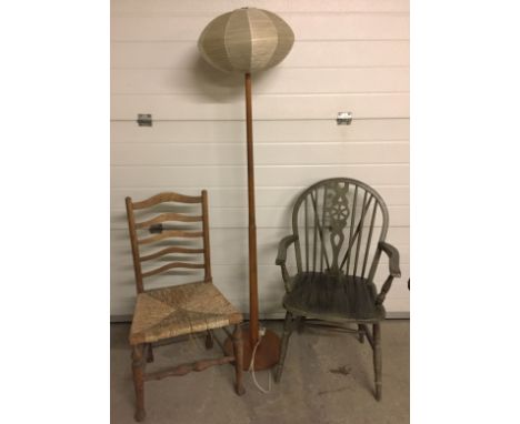 A rush seated ladder back chair together with a wheel back chair and wooden standard lamp.