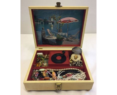 A c.1960s musical jewellery box with key. Inside there is a miniature record deck which rotates when the music plays. Full of