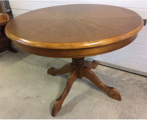 A light oak circular extending dining table on pedestal.
