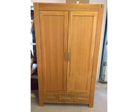 A modern solid wood light oak 2 door wardrobe with 3 drawers and double hanging space. Approx 106 x 184cm