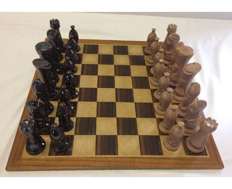 A modern wooden chess board with ceramic playing pieces. Some pieces (a/f).