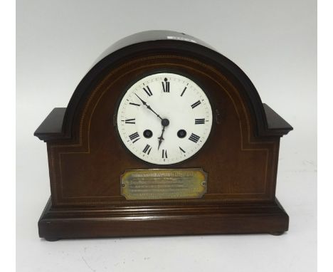 An Edwardian mantel clock in a mahogany inlaid case with presentation plaque to 'D.Hirst'.