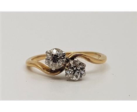 An 18ct. gold two stone diamond crossover ring, set old-cut diamonds, (gross weight 2.4g)