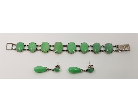 A Chinese white gold and jade bracelet, having links set graduated oval cabochon green jade, stamped "18K" and character mark